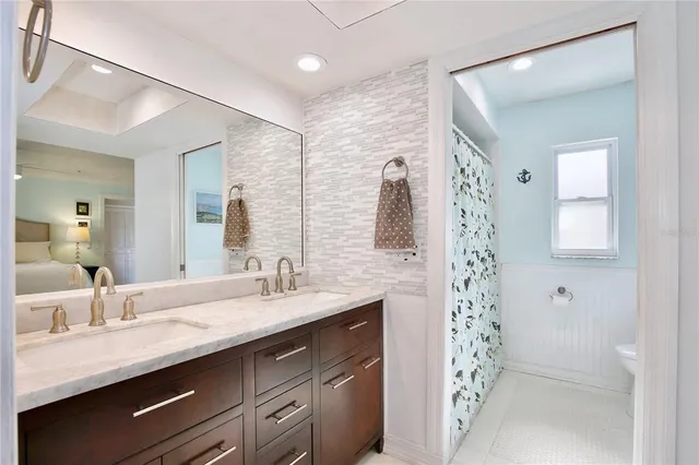 a bathroom with a double vanity sink mirror and shower