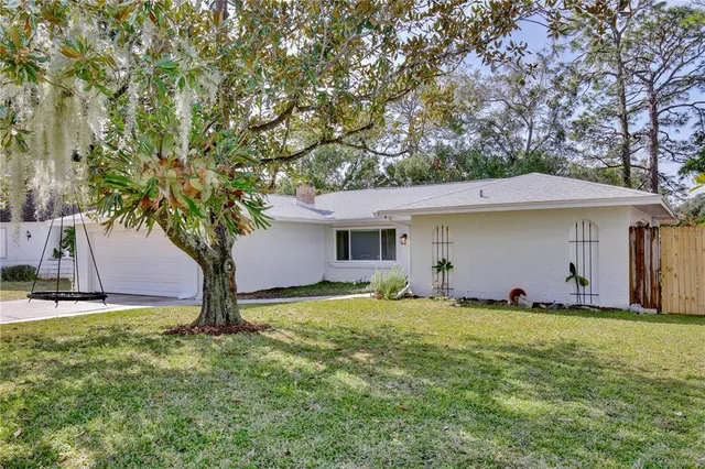 a view of a house with a yard and tree