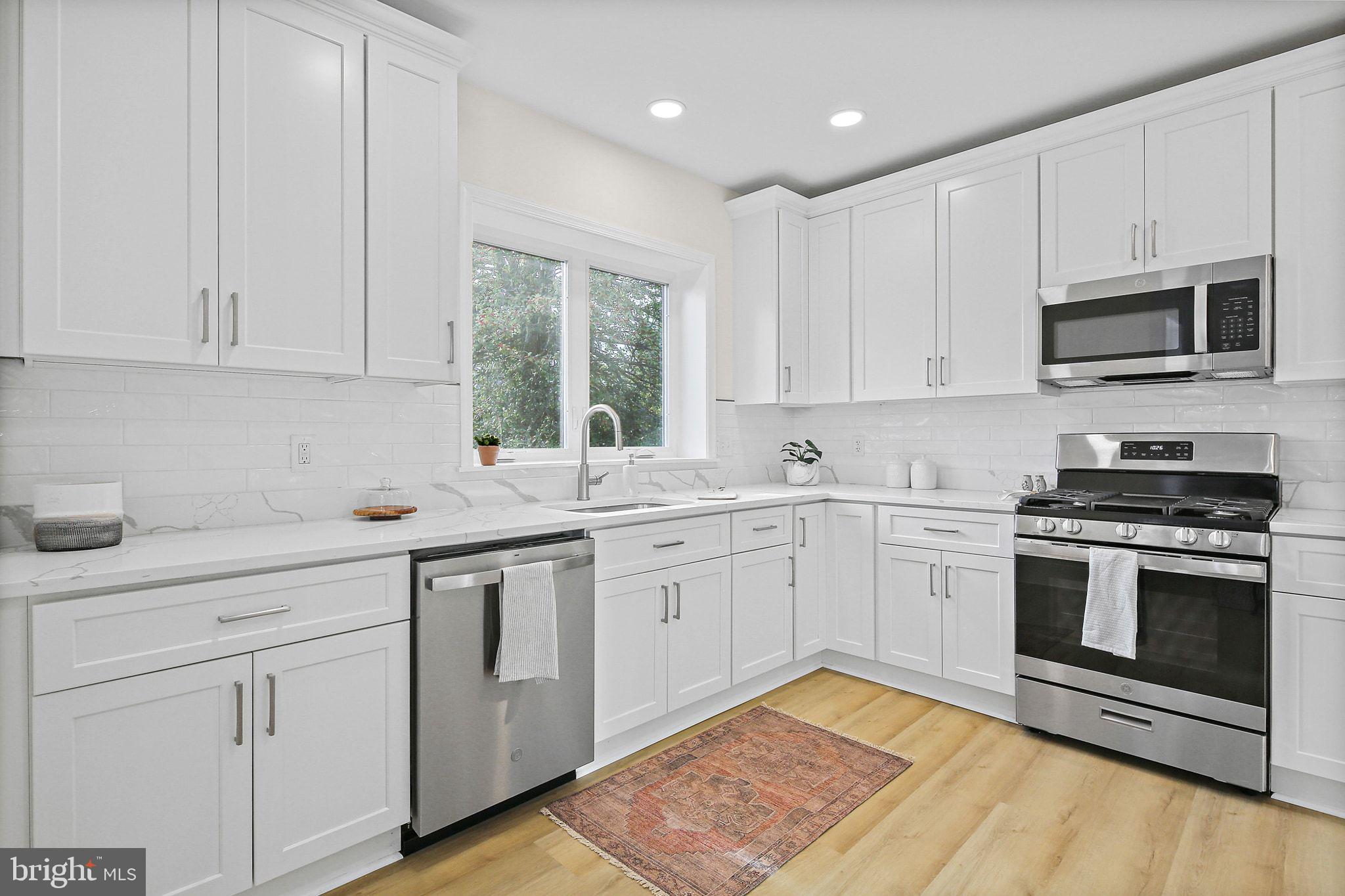 402 Westgate Road Baltimore, MD 21229 - Photo 12 of 37 a kitchen with granite countertop white cabinets stainless steel appliances and a sink