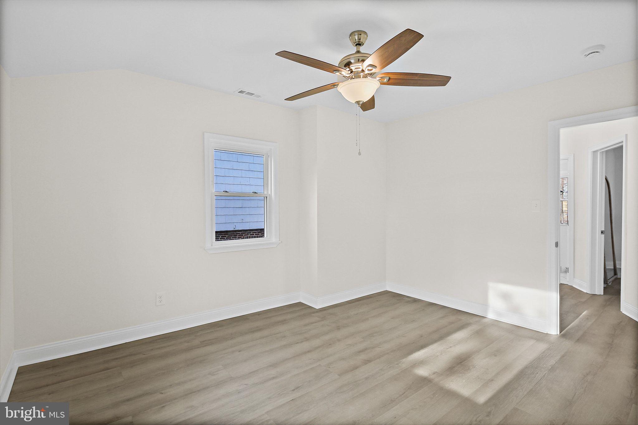 402 Westgate Road Baltimore, MD 21229 - Photo 17 of 37 an empty room with wooden floor and a ceiling fan