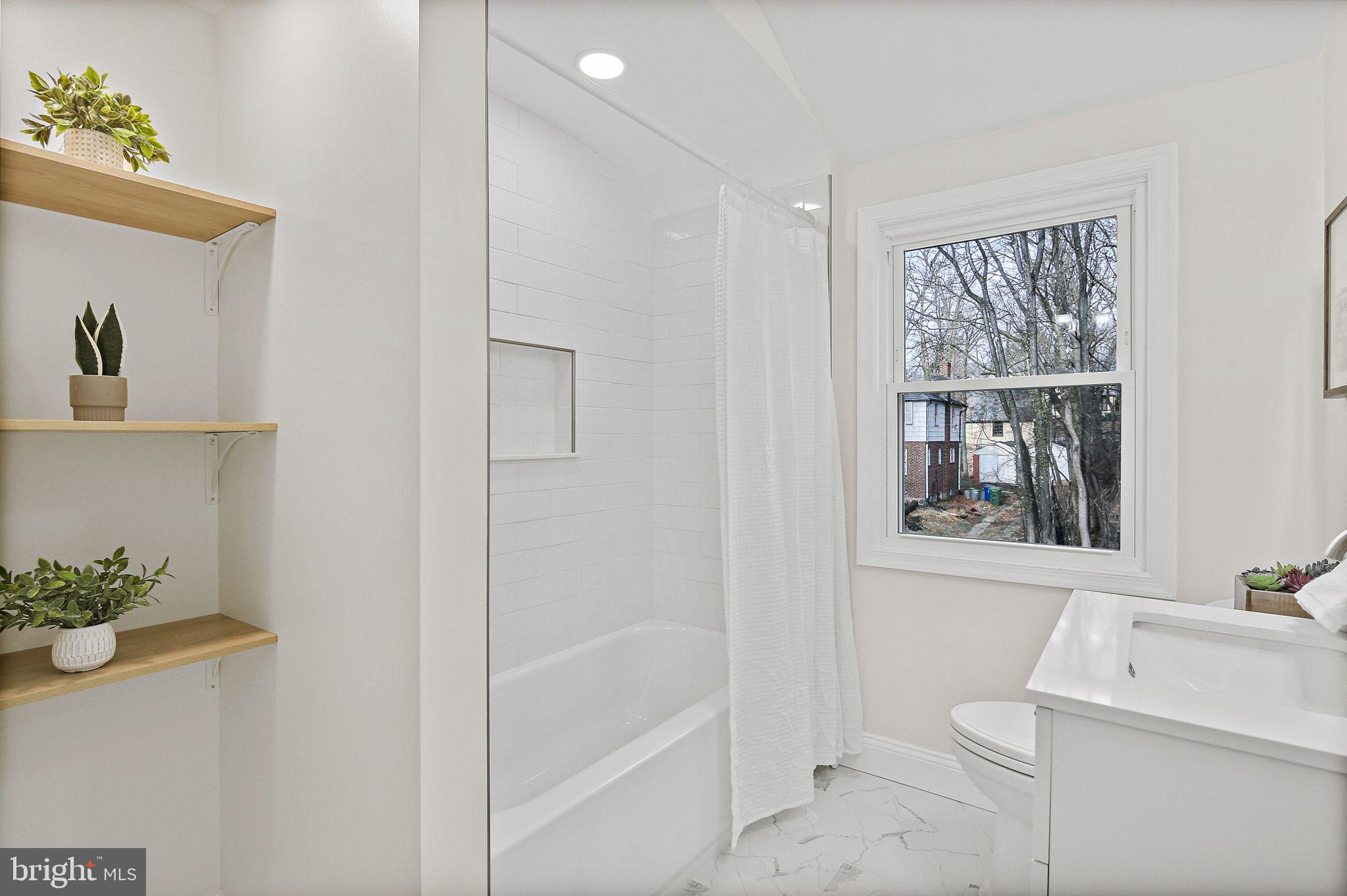 402 Westgate Road Baltimore, MD 21229 - Photo 24 of 37 a bathroom with a shower a window and a sink