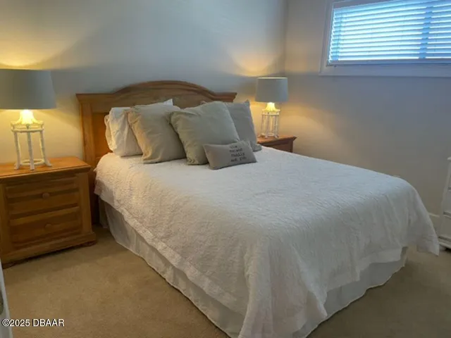 a large bed sitting in a bedroom next to a lamp
