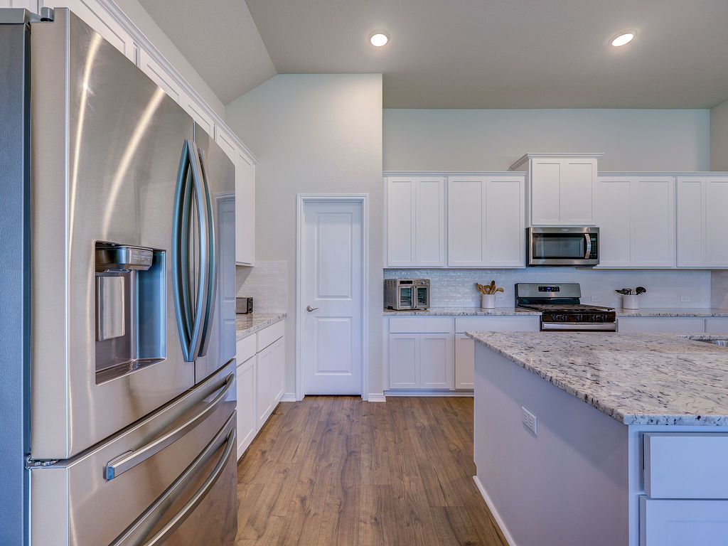 229 Heartleaf Road San Marcos, TX 78666 - Photo 12 of 40 A well-appointed kitchen features a large central island and gleaming stainless steel appliances.