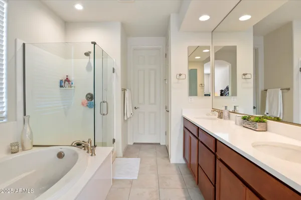 a bathroom with a tub sink shower and mirror