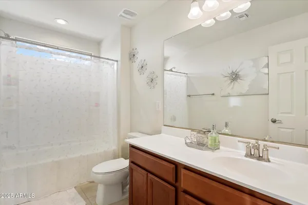 a bathroom with a sink a toilet a mirror and shower