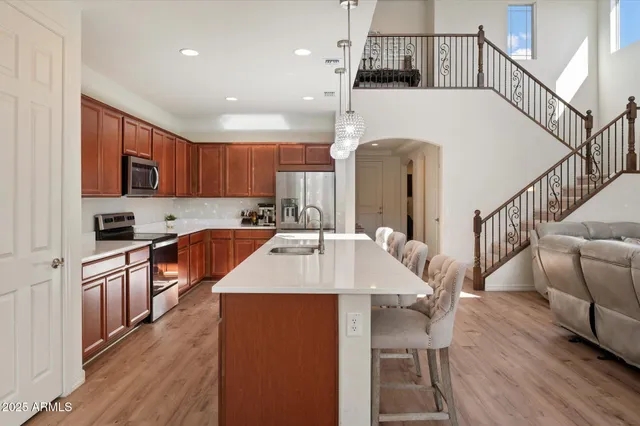 a large kitchen with cabinets wooden floor and stainless steel appliances