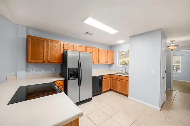 a kitchen with a refrigerator a stove top oven and cabinets