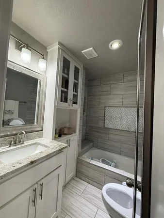 a bathroom with a granite countertop sink toilet and shower
