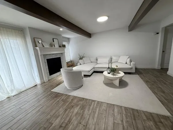 a living room with furniture a fireplace and wooden floor