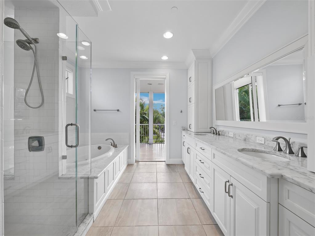 333 Firehouse Court Longboat Key, FL 34228 - Photo 16 of 83 a spacious bathroom with a double vanity sink a large mirror shower and bathtub