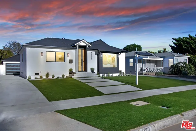 a front view of a house with a garden and yard