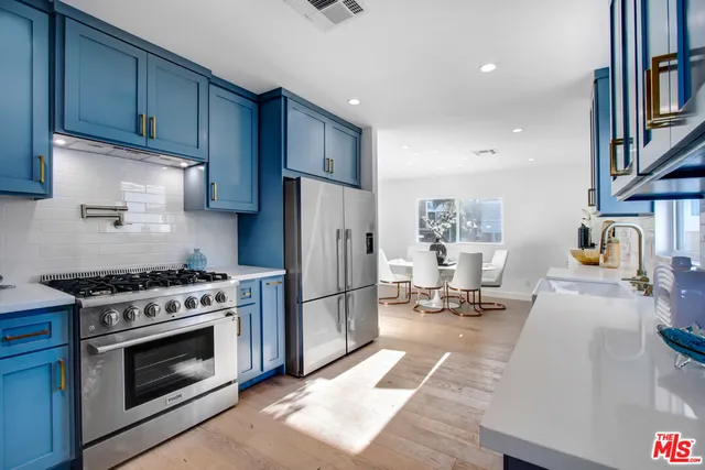 a kitchen with stainless steel appliances a stove a sink and a refrigerator