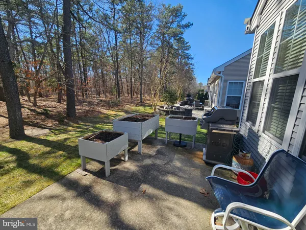 a view of a backyard with table and chairs couches and wooden fence