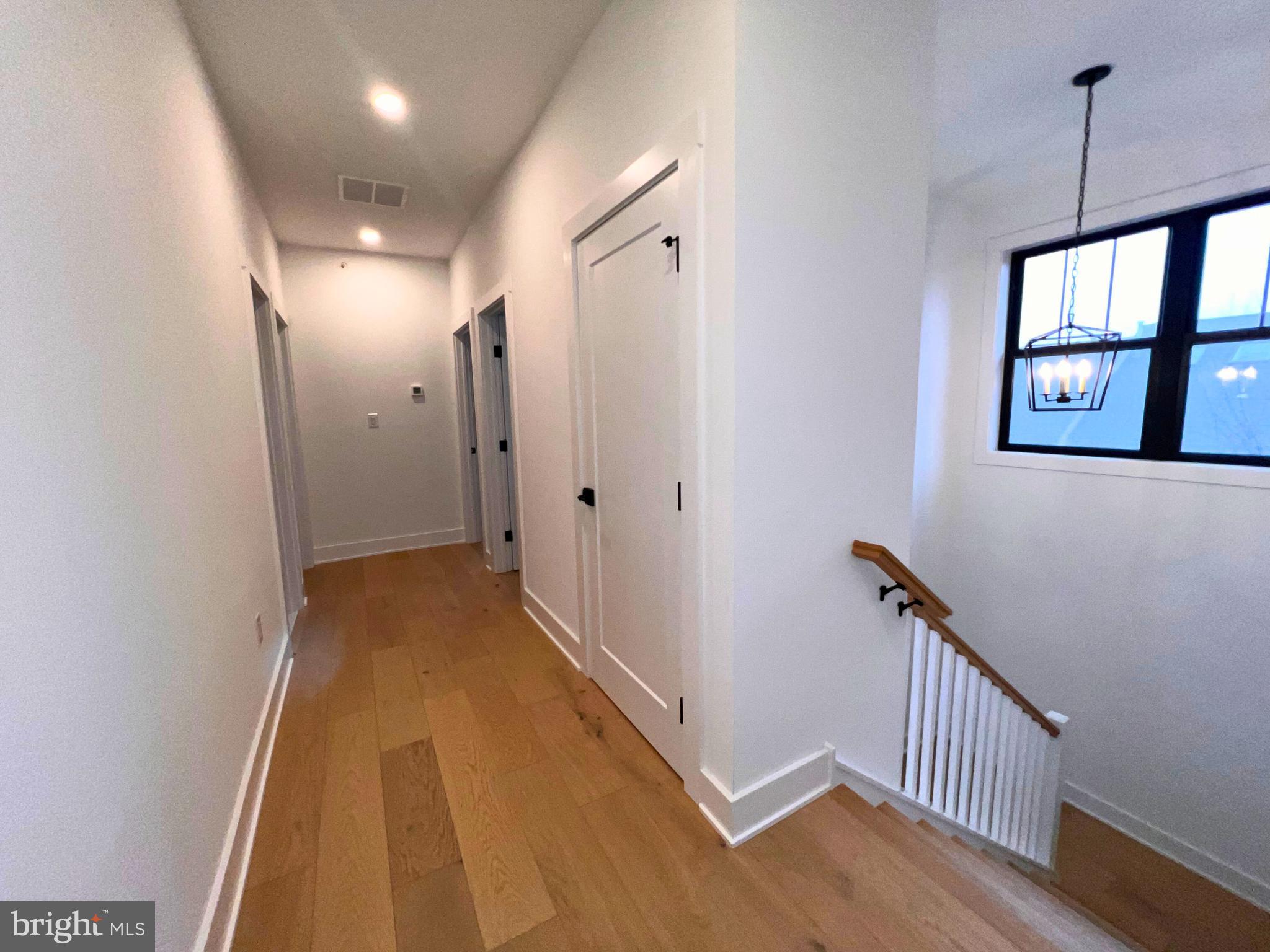 986 Henry Avenue Wayne, PA 19087 - Photo 13 of 32 a view of a hallway to a room with wooden floor and windows