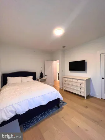 a spacious bedroom with a bed and a flat screen tv