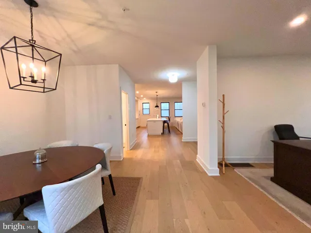 a view of dining room and livingroom with furniture wooden floor a rug and a chandelier