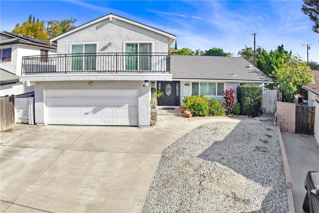 11800 Gager Street Sylmar, CA 91342 - Photo 3 of 25 a front view of a house with a yard and garage