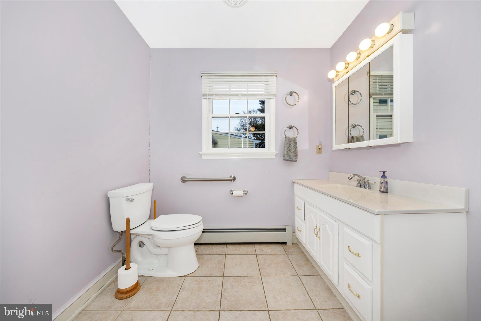 9 East 13th Street Frederick, MD 21701 - Photo 19 of 51 a bathroom with a toilet a sink a mirror and a window