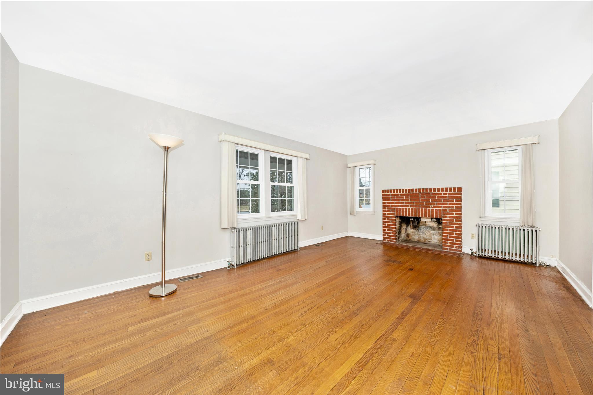 9 East 13th Street Frederick, MD 21701 - Photo 8 of 51 an empty room with wooden floor and fireplace