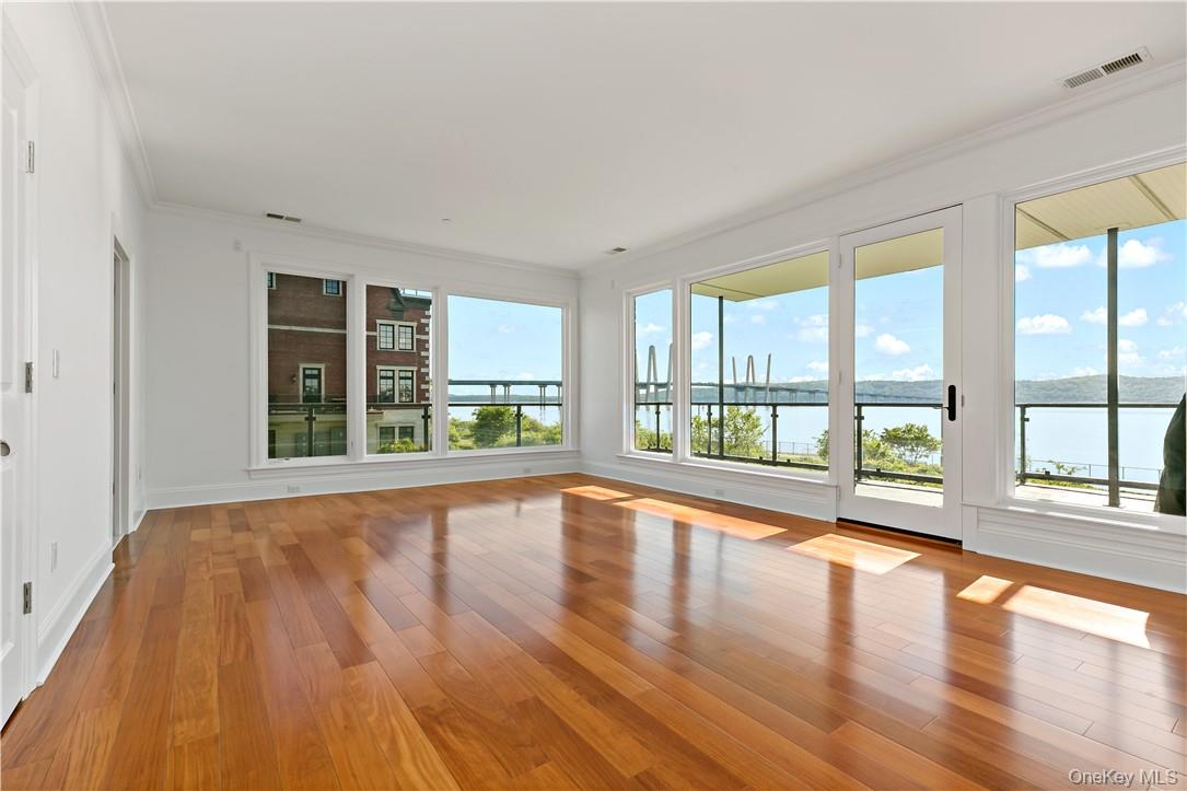 16 Rivers Edge Drive, Unit 200 Tarrytown, NY 10591 - Photo 1 of 19 a view of an empty room with wooden floor and a window