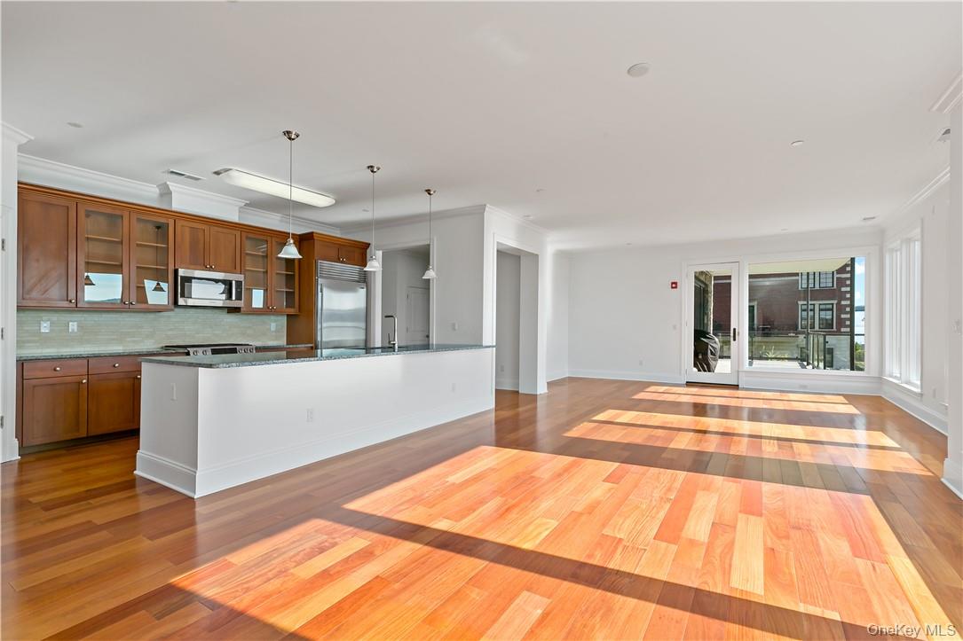 16 Rivers Edge Drive, Unit 200 Tarrytown, NY 10591 - Photo 2 of 19 a view of a kitchen with kitchen island a sink wooden floor and glass door