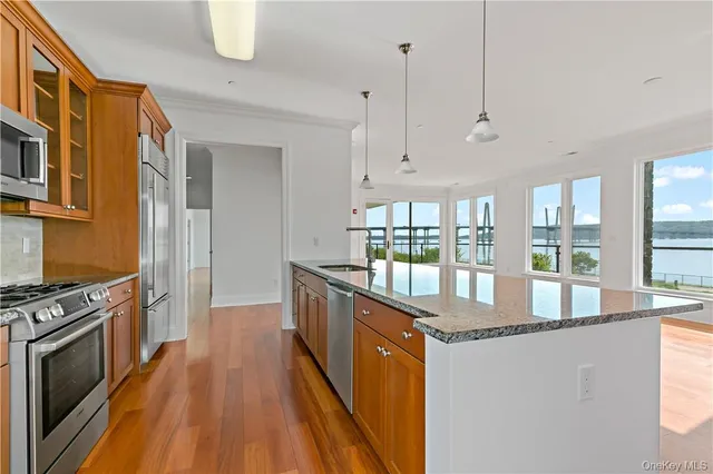 a kitchen with stainless steel appliances granite countertop a stove and a wooden floors