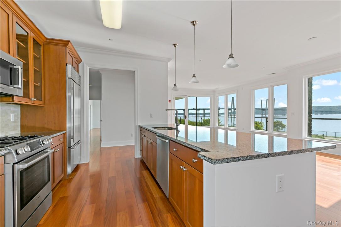 16 Rivers Edge Drive, Unit 200 Tarrytown, NY 10591 - Photo 5 of 19 a kitchen with stainless steel appliances granite countertop a stove and a wooden floors
