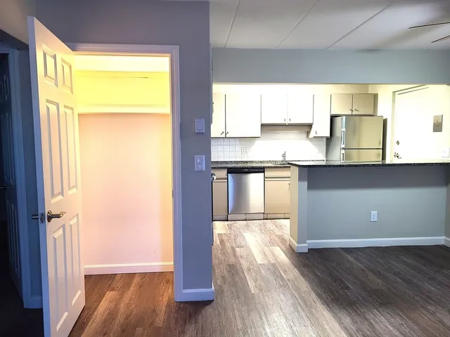 a view of a kitchen with wooden floor and a window