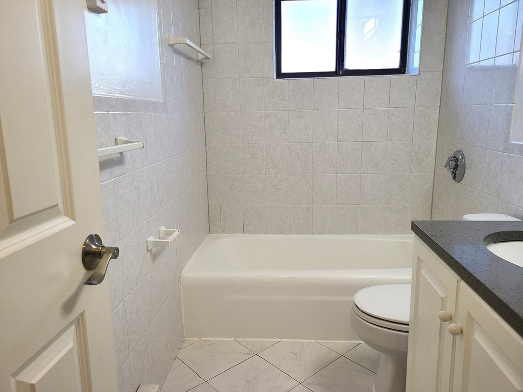 576 Washington Street, Unit 114 Weymouth, MA 02188 - Photo 18 of 24 a bathroom with a sink a toilet and bathtub