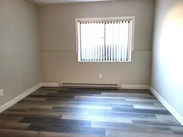 a view of a room with wooden floors and a window