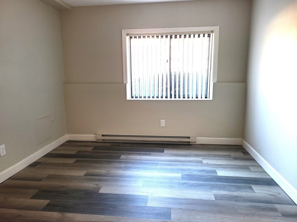 576 Washington Street, Unit 114 Weymouth, MA 02188 - Photo 19 of 24 a view of a room with wooden floors and a window