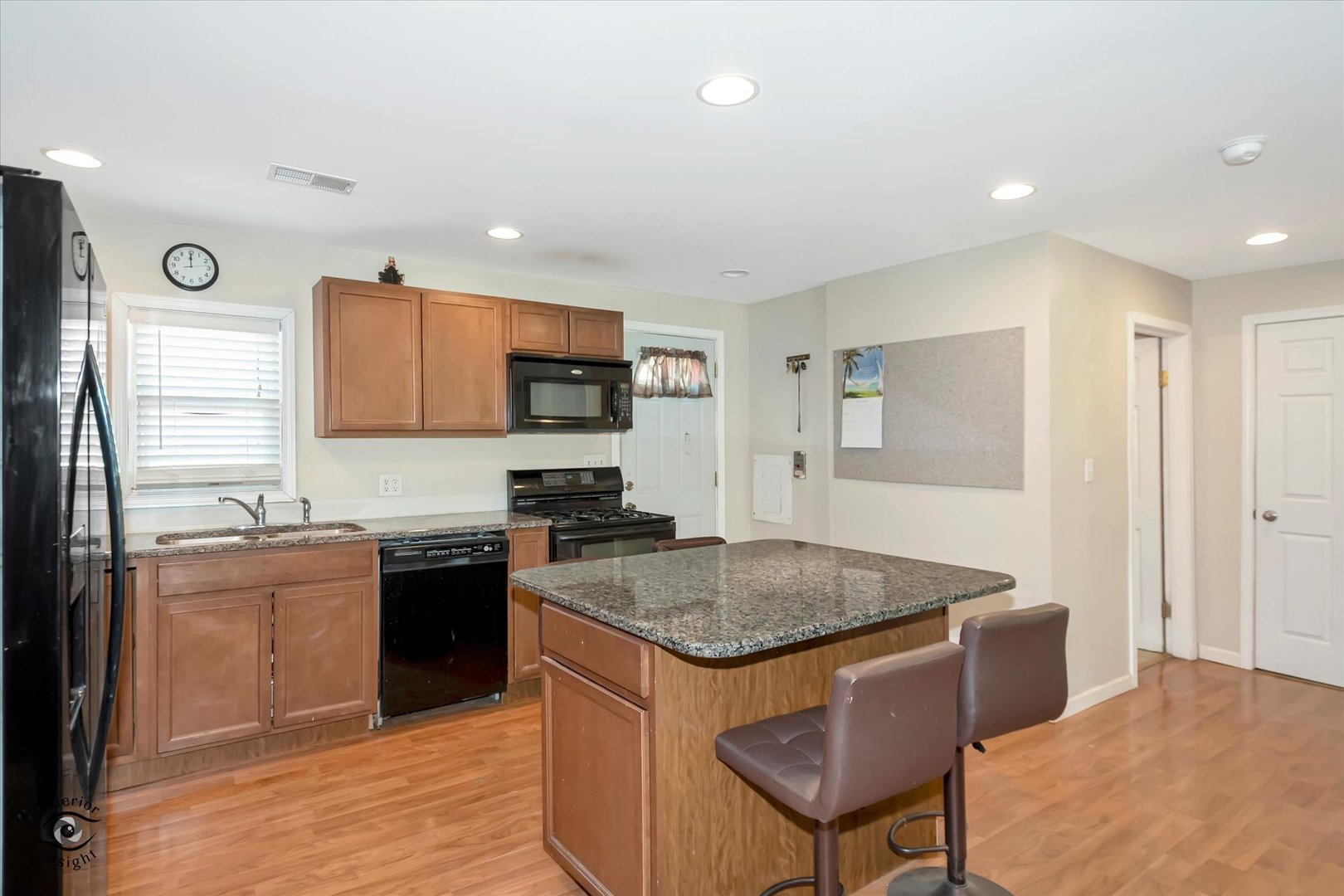 833 South Prairie Road New Lenox, IL 60451 - Photo 8 of 25 a kitchen with granite countertop a stove top oven a sink dishwasher and a refrigerator with wooden floor