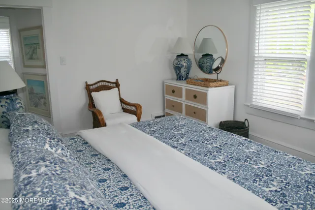 a bedroom with a bed and a dresser with mirror