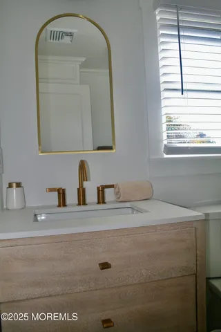 a bathroom with a sink vanity and a mirror