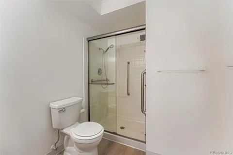 a bathroom with a granite countertop toilet and a shower