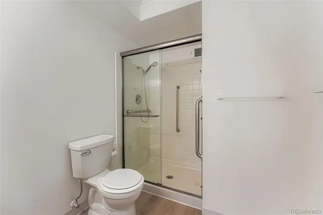 a bathroom with a granite countertop toilet and a shower