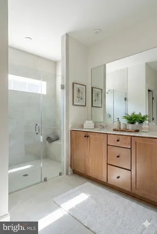 a spacious bathroom with a granite countertop sink mirror and shower