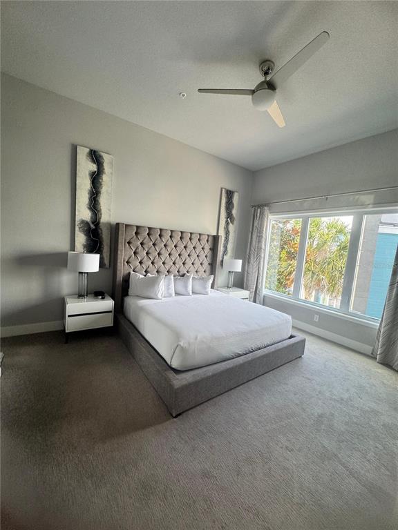 7770 Sandy Ridge Drive, Unit 210 Reunion, FL 34747 - Photo 20 of 42 a bedroom with a bed lamp and window