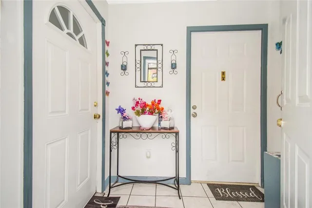 a hallway with painting on the wall and a refrigerator