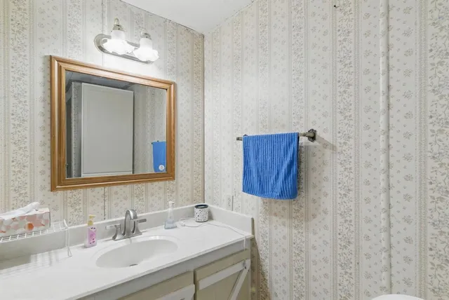 a bathroom with a glass shower door and a mirror