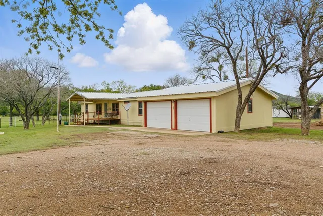 a front view of house with yard and trees around