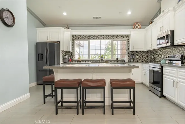 a kitchen with stainless steel appliances granite countertop a table and chairs in it