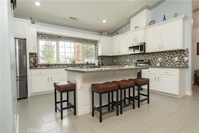 a kitchen with appliances cabinets and a large window