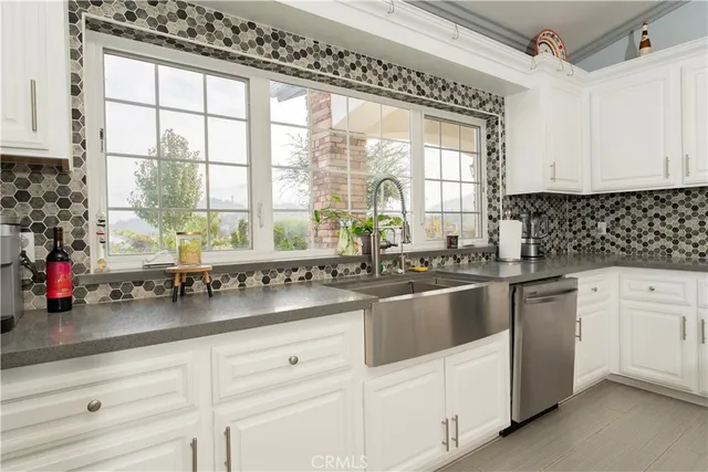 a kitchen with granite countertop a sink stove and cabinets