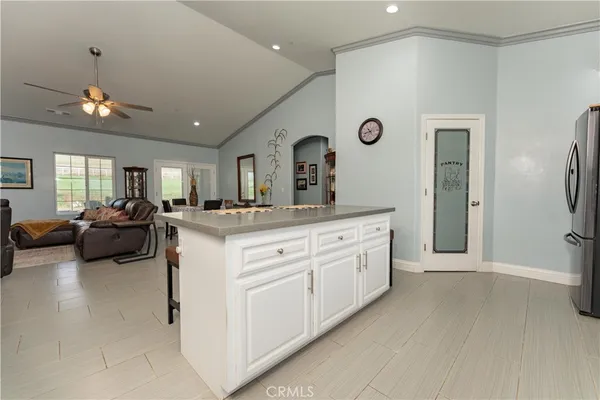 a living room with furniture kitchen view and a chandelier