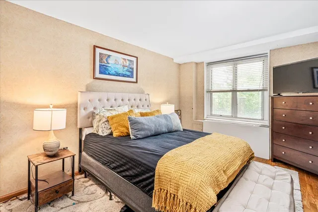 a bedroom with a bed and wooden floor