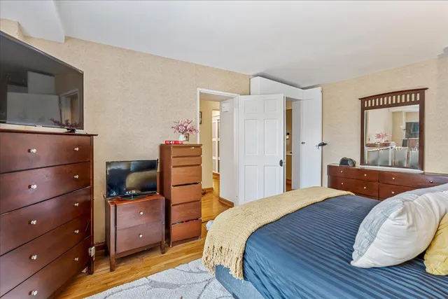a bedroom with a bed and wooden floor