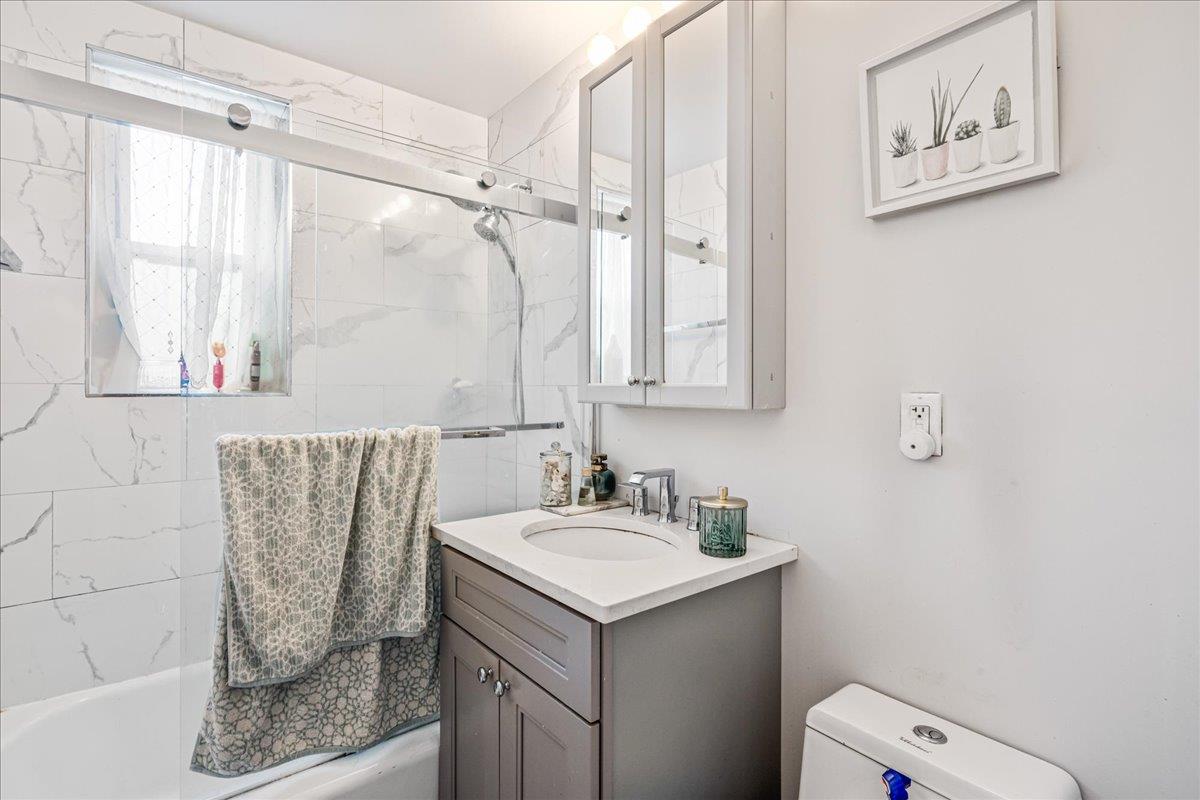 211-10 18th Avenue, Unit 2J Queens, NY 11360 - Photo 20 of 24 a bathroom with a sink a toilet and shower
