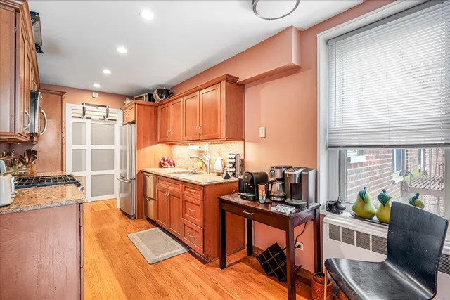a kitchen with granite countertop a stove and white cabinets