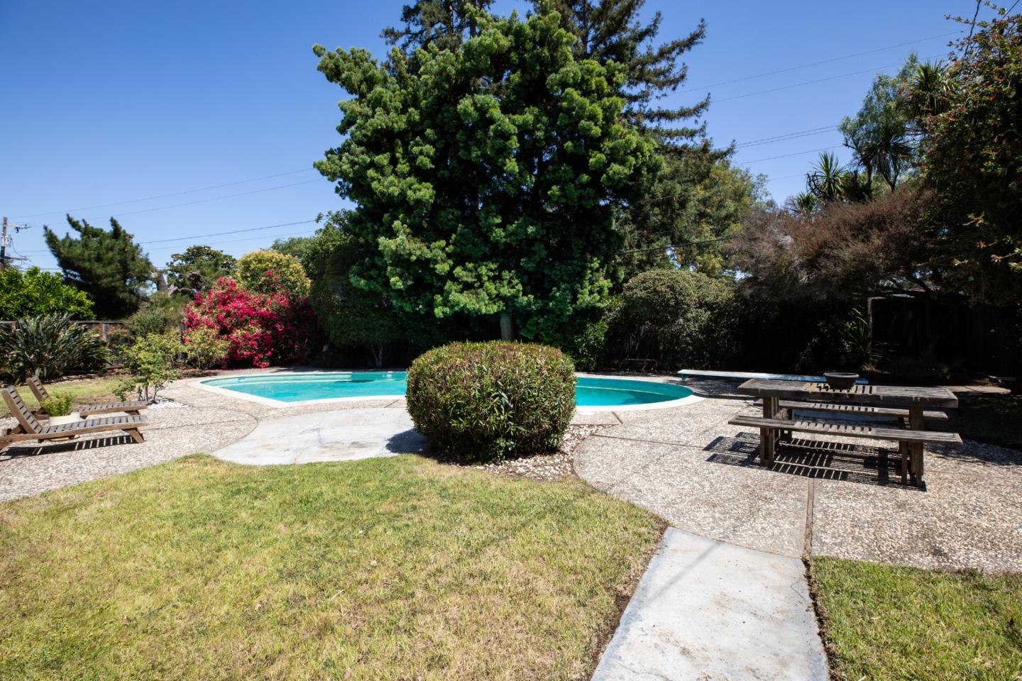 1208 Fairbrook Drive Mountain View, CA 94040 - Photo 3 of 5 a view of a backyard with table and chairs potted plants and large tree